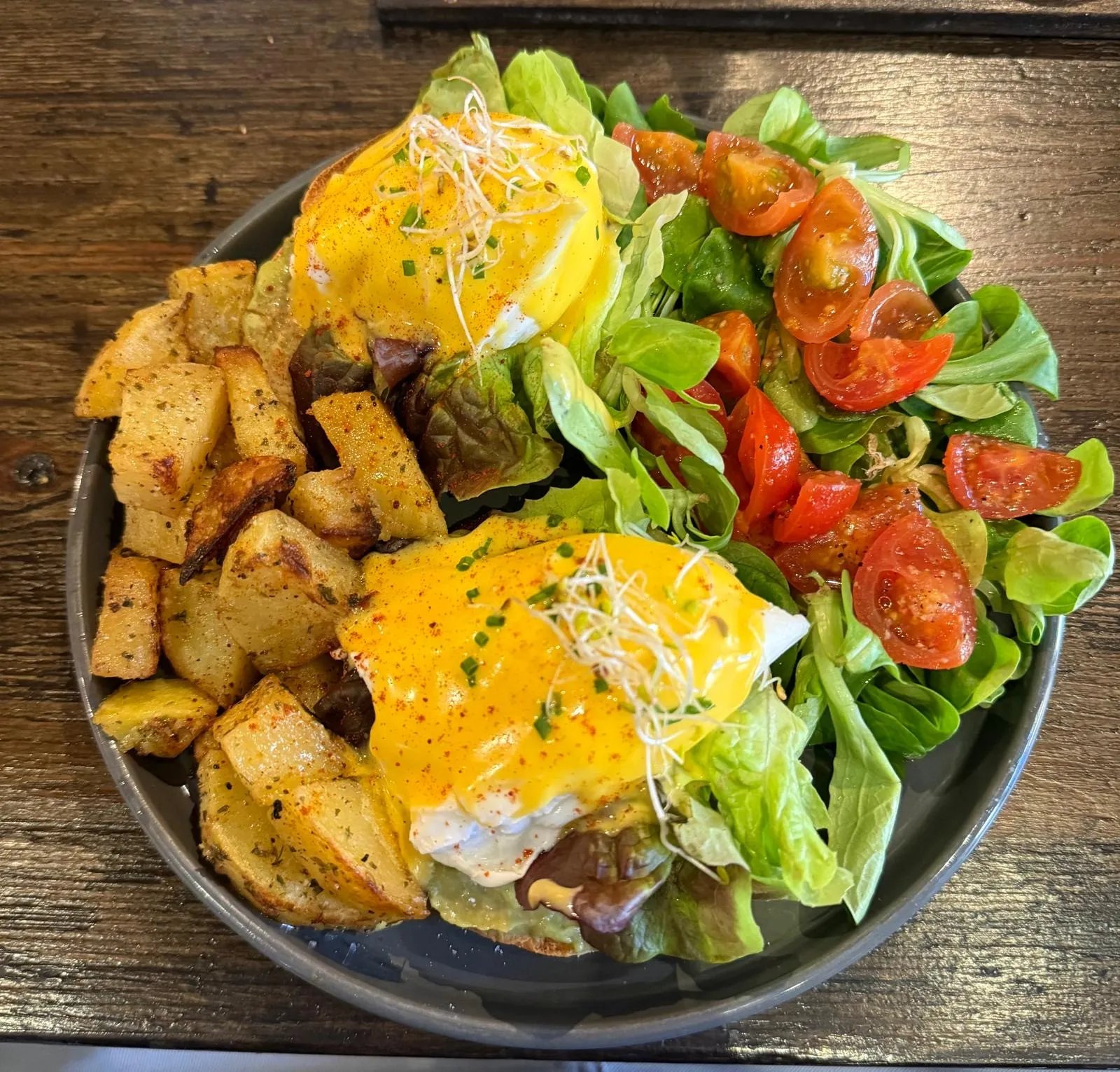 Ous Benedict amb patates rostides i amanida de tomàquet